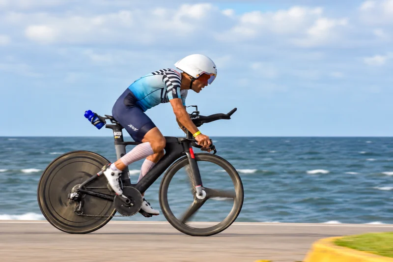 Ciclista con casco blanco en la rambla de Punta del Este durante el Ironman 70.3