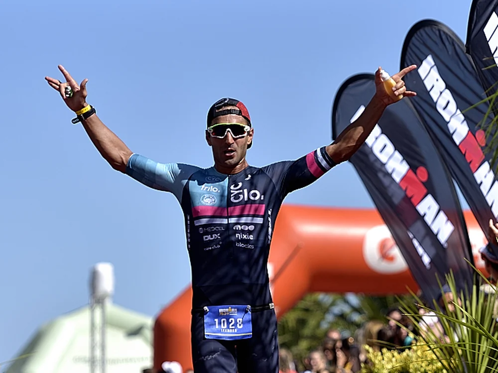 Triatleta cruzando la meta del Ironman 70.3 Punta del Este con los brazos en alto